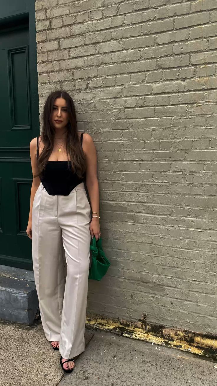 Black tank top tucked into cream Aritzia Effortless Pant